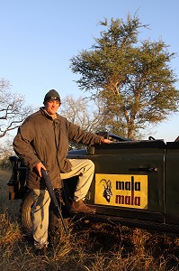 RANGER SUD-AFRICAIN POSANT DEVANT SON 4X4 RANGE ROVER AU LEVER DU SOLEIL, RESERVE PRIVEE DE MALA MALA, RESERVE FAUNIQUE DE SABIE SAND, PARC NATIONAL DU KRUGER, AFRIQUE DU SUD 