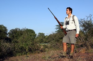 RANGER SUD-AFRICAIN POSANT AVEC SON FUSIL, LODGE SINGITA LEBOMBO, RELAIS ET CHATEAUX, PARC NATIONAL DU KRUGER, AFRIQUE DU SUD 