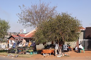 VENDEURS DE SOUVENIRS DANS UNE RUE DU QUARTIER DE SOWETO AVEC AU LOIN LES TOURS DE L'ANCIENNE CENTRALE ELECTRIQUE D'ORLANDO, QUARTIER RESERVE AUX NOIRS PENDANT LA PERIODE DE L'APARTHEID, JO'BURG, JOHANNESBURG, ETAT DU GAUTENG, AFRIQUE DU SUD 