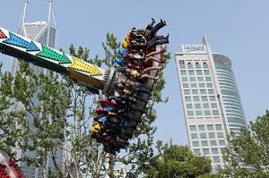 CARROUSEL DANS LE PARC RENMIN SUR FOND D'IMMEUBLES DE BUREAU, PEOPLE'S SQUARE, QUARTIER DE PUXI, SHANGHAI, REPUBLIQUE POPULAIRE DE CHINE 