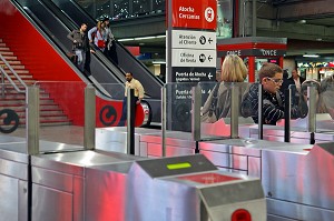 VOYAGEURS DEVANT LES BORNES DE PEAGE (BILLETS DE TRAIN), GARE D'ATOCHA, MADRID, ESPAGNE 