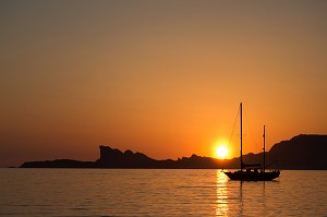 SOUS UN SOLEIL COUCHANT, UN VOILIER LARGUE SES AMARRES ENTRE LES ILES ET LA PLAGE DU PROPHETE, MARSEILLE, VUE MARITIME ET PROMENADE EN BORD DE MEDITERRANEE 