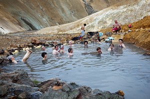 TOURISTES SE BAIGNANT DANS UNE SOURCE D'EAU CHAUDE NATURELLE SUR LES MONTS KERLINGARFJOLL, HAUTES TERRES D’ISLANDE, EUROPE 