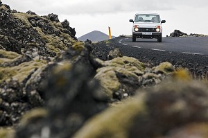 VEHICULE TOUT TERRAIN 4X4 SUR LA ROUTE LE LONG D'UN CHAMP DE LAVE RECOUVERT DE MOUSSE ET DE LICHEN, GRINDAVIK, REGION DU BLUE LAGOON, SUD OUEST DE L'ISLANDE, EUROPE 