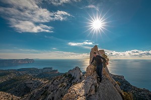 RANDONNEUR SUR UNE ARETE ROCHEUSE, MER ET CALANQUES EN ARRIERE-PLAN, MARSEILLE, BOUCHES-DU-RHONE (13), PROVENCE-ALPES-COTE D'AZUR, FRANCE 