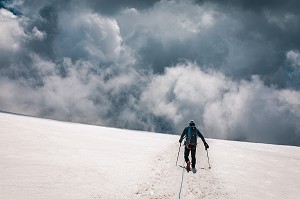 ALPINISTE DESCENDANT UN GLACIER SOUS UN TEMPS ORAGEUX, MASSIF DU MONT-ROSE, GRESSONEY-LA-TRINITE, VAL D'AOSTE, ITALIE 