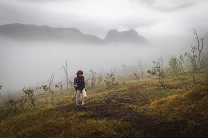 RANDONNEUSE EN MONTEE DANS LA BRUME VERS LE MONT GRYTETIPPEN, SENJA, NORVEGE 