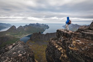 RANDONNEUSE SUR UN PROMONTOIRE AU SOMMET DU GRYTETIPPEN AU DESSUS DES FJORDS ET DES MONTAGNES DE L'ILE DE SENJA, NORVEGE 