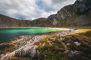 RANDONNEUSE APPROCHANT DE LA PLAGE DE HOYVIKA, SABLE BLANC ET EAU TURQUOISE ENTOURÉS DE MONTAGNES, STAVE, ANDOYA, NORVEGE 