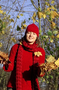 SYMBIOSE AVEC LA NATURE. JEUNE FEMME COUCHEE SUR UN TAPIS DE FEUILLES MORTES EN AUTOMNE 