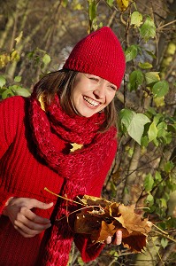 SYMBIOSE AVEC LA NATURE. JEUNE FEMME COUCHEE SUR UN TAPIS DE FEUILLES MORTES EN AUTOMNE 
