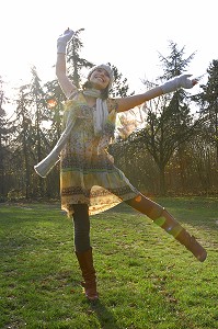 JOIE DE VIVRE ET ENERGIE POSITIVE EN AUTOMNE, SAISON MORNE. JEUNE FEMME DANSANT DANS UNE FORET 