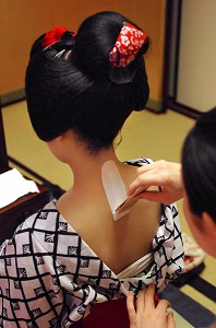 MAQUILLAGE TRADITIONNEL (DORAN) D’UNE MAIKO (APPRENTIE GEISHA), APPLICATION DU FARD BLANC (SHIRONURI) SUR LA NUQUE AVEC UN PINCEAU DE BAMBOU (BURASHI), LA COIFFURE DE LA MAIKO EST UN CHIGNON EN FORME DE PECHE FENDUE (WARESHINOBU) ORNE DE RUBANS EN SOIE (KANOKO), QUARTIER DE GION, KYOTO, JAPON, ASIE 