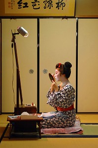 MAQUILLAGE TRADITIONNEL (DORAN) D’UNE MAIKO (APPRENTIE GEISHA), APPLICATION DU FARD BLANC (SHIRONURI) AVEC UN PINCEAU DE BAMBOU (BURASHI), LA MAIKO A UN CHIGNON EN FORME DE PECHE FENDUE (WARESHINOBU) ORNE DE RUBANS ROUGES EN SOIE (KANOKO) ET PORTE UN KIMONO DE COTON (YUKATA), QUARTIER DE GION, KYOTO, JAPON, ASIE 