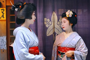 PORTRAIT D'UNE GEIKO (GEISHA), A GAUCHE, ET D'UNE MAIKO (APPRENTIE) PORTANT UN KIMONO (OBEBE) FERME PAR UNE CEINTURE LARGE (OBI), DEVANT UNE MAISON DE GEISHA (OKIYA), QUARTIER DE GION, KYOTO, JAPON, ASIE 