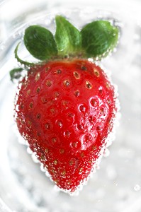 FRAISE PLONGEE DANS L'EAU GAZEUSE, FRUIT ROUGE RICHE EN VITAMINE A ET C ANTIOXYDANTE MAIS POUVANT PROVOQUER DES ALLERGIES 