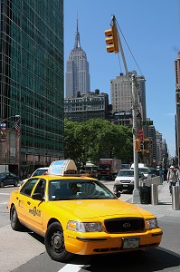 TAXI TOURNANT DANS UNE RUE, AVEC L'EMPIRE STATE BUILDING ET BRYANT PARK EN FOND, QUARTIER DE MIDTOWN, MANHATTAN, NEW YORK CITY, ETAT DE NEW YORK, ETATS-UNIS 