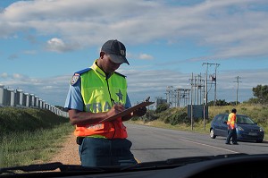POLICIER NOTANT LA PLAQUE D'IMMATRICULATION DU VEHICULE LORS D'UN CONTROLE ROUTIER A LA SORTIE DE LA VILLE DE SAINT-FRANCIS, ROUTE DES JARDINS, PROVINCE DU CAP OCCIDENTAL, AFRIQUE DU SUD 