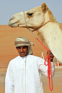 CHAMELIER POSANT AVEC SON DROMADAIRE DANS LE COMPLEXE TOURISTIQUE DESERT NIGHT CAMP, DESERT DE WAHIBA SANDS, SULTANAT D'OMAN, MOYEN-ORIENT 
