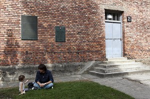 PERE JOUANT AVEC SON BEBE DEVANT L'ENTREE DU BLOC 21 DU CAMP DE CONCENTRATION D'AUSCHWITZ I, MUSEE D'ETAT D'AUSCHWITZ-BIRKENAU, SITE CLASSE PATRIMOINE MONDIAL DE L'UNESCO, OSWIECIM, SILESIE, POLOGNE 