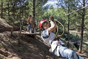 ENFANT SUR UNE TYROLIENNE, ACCRO-PARK (PARC ACCROBRANCHE DANS LES ARBRES), DOMAINE DE TERRES D’AMANAR, TAHANAOUTE, AL HAOUZ, MAROC 