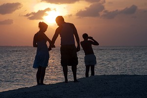 FAMILLE CONTEMPLANT LE COUCHER DE SOLEIL SUR L'ILE DE KURAMATHI, ATOLL DE RASDHOO, MALDIVES, OCEAN INDIEN 