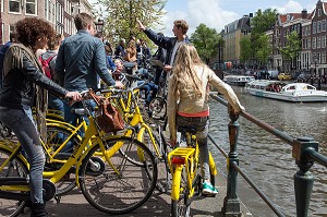 GROUPE DE TOURISTES A VELO JAUNE (YELLOW BIKE) AVEC UN GUIDE TOURISIQUE, PRINCENGRACHT, VILLE D'AMSTERDAM, PAYS-BAS 