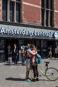 COUPLE D'AMOUREUX EN VELO DEVANT LA GARE DE CENTRAL STATION (AMSTERDAM CENTRAAL), VILLE D'AMSTERDAM, PAYS-BAS 