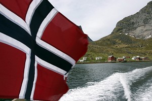 DRAPEAU NORVEGIEN SUR UN BATEAU DANS LE FJORD DE REINE, REINE, ILE DE FLAKSTADOY, ARCHIPEL DES ILES LOFOTEN, LOFOTEN, NORVEGE 
