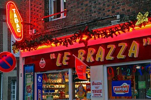 ENSEIGNE D'UN BAR TABAC 'LE BRAZZA' A LA TOMBEE DE LA NUIT AVEC VITRINE POUR LA PROMOTION DES JEUX DE HASARD (TICKETS A GRATTER, RAPIDO, FRANCAISE DES JEUX), FRANCE 