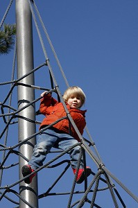 ESCALADE DES CORDES DE LA TOILE D'ARAIGNEE (STRUCTURE GRIMPANTE) PAR UN PETIT GARCON, AIRE DE JEUX POUR ENFANTS, JARDIN D'ACCLIMATATION, PARIS, FRANCE 