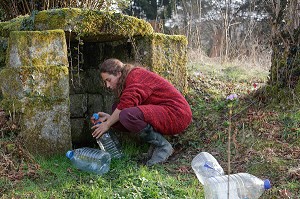 LORELEI VA CHERCHER L'EAU A LA SOURCE EN BAS DE SON TERRAIN, ELLE A TOUT QUITTE POUR CONSTRUIRE ET HABITER SA CABANE EN BOIS AU MILIEU DE LA CREUSE, FRANCE 