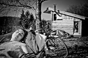 LORELEI FAIT LA SIESTE DANS SON HAMAC, ELLE A TOUT QUITTE POUR CONSTRUIRE ET HABITER SA CABANE EN BOIS AU MILIEU DE LA CREUSE, FRANCE 