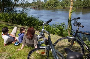 FAMILLE DE CYCLISTES ASSIS SUR LES BORDS DU FLEUVE, PARCOURS DE LA LOIRE EN VELO, VILLAGE DE CANDES-SAINT-MARTIN, INDRE-ET-LOIRE (37), FRANCE 