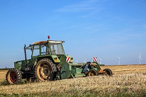 TRACTEUR AU TRAVAIL DE LA TERRE DEVANT DES EOLIENNES, EURE-ET-LOIR (28), FRANCE 