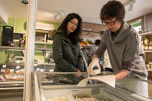 NATHALIE DE WEVER, COMMERCANTE, SERVANT UN FROMAGE FRAIS A UNE CLIENTE, MAGASIN LOCAVORE 'GOUT ET TRADITION', RUGLES, EURE (27), FRANCE 