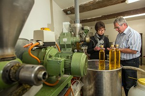JEAN-MARIE LENFANT, PRODUCTEUR D'HUILE DE COLZA ET DE TOURNESOL, FAISANT GOUTER SA PRODUCTION A NATHALIE DE WEVER, COMMERCANTE ADHERENTE DU MOUVEMENT LOCAVORE, DEVANT DES BOUTEILLES D'HUILE DE COLZA, LA COUTURE-BOUSSEY, EURE (27), FRANCE 