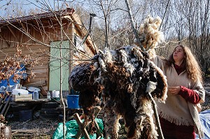 LORELEI CARDE LA LAINE DE MOUTON A LA MAIN AVANT DE LA NETTOYER, ELLE A TOUT QUITTE POUR CONSTRUIRE ET HABITER SA CABANE EN BOIS AU MILIEU DE LA CREUSE, FRANCE 