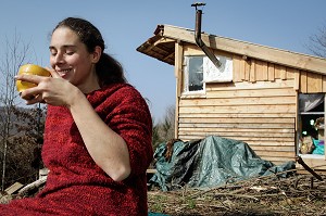 LORELEI BOIT SON BOL DE THE DEVANT SA CABANE, ELLE A TOUT QUITTE POUR CONSTRUIRE ET HABITER SA CABANE EN BOIS AU MILIEU DE LA CREUSE, FRANCE 