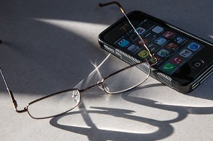 LA PAIRE DE LUNETTES DE VUE ET LE TELEPHONE SMARTPHONE IPHONE, 