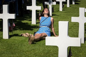JEUNE FEMME ALLONGEE AU MILIEU DES CROIX BLANCHES DES SOLDATS MORTS LORS DE LA DEUXIEME GUERRE MONDIALE, COMMEMORATION AU CIMETIERE AMERICAIN, CEREMONIE DU 70 EME ANNIVERSAIRE DU DEBARQUEMENT EN NORMANDIE, COLLEVILLE-SUR-MER (14), FRANCE 
