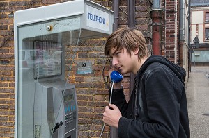 ADOLESCENT TELEPHONE DANS UNE CABINE TELEPHONIQUE DE FRANCE TELECOM, RUGLES,  (27) EURE, FRANCE 