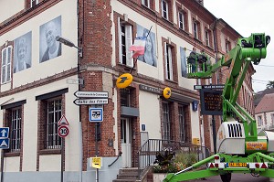 COLLAGE AVEC UNE NACELLE DES PHOTOS GEANTES SUR LES MURS (LA POSTE) DE LA VILLE POUR LE FESTIVAL CULTUREL RUGL'ART, RUGLES, (27) EURE, FRANCE 