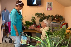 VISITE DE L'AIDE SOIGNANTE DANS LA CHAMBRE D'UNE RESIDENTE AVEC SES PLANTES VERTES, EHPAD ANDRE COUTURIER, ETABLISSEMENT PUBLIC DU SUD DE L'EURE, HEBERGEMENT POUR PERSONNES AGEES INDEPENDANTES, RUGLES, EURE (27), FRANCE 