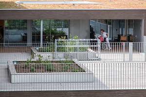 AIDE-SOIGNANTE POUSSANT LE FAUTEUIL D'UN RESIDENT SUR LA TERRASSE DU PETIT JARDIN, EHPAD ANDRE COUTURIER, ETABLISSEMENT PUBLIC DU SUD DE L'EURE, HEBERGEMENT POUR PERSONNES AGEES INDEPENDANTES, RUGLES, EURE (27), FRANCE 