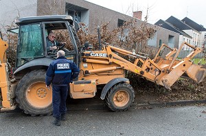 POLICIER MUNICIPAL DEVANT LE TRACTOPELLE POUR L'ARRACHAGE D'UNE HAIE, VILLE DE RUGLES (27), FRANCE 