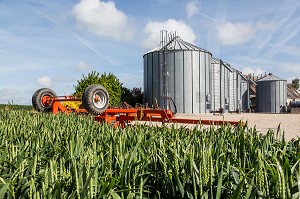 CHAMP DE BLE ET MATERIEL AGRICOLE DEVANT LES SILOS A GRAIN, FERME DE FRANCOIS LORIN, TERROIR DE TERRES D'EURE-ET-LOIR, DIGNY (28), FRANCE 