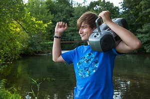 JEUNE ADOLESCENT QUI CHANTE ET ECOUTE DE LA MUSIQUE DANS LA NATURE, RUGLES (27), FRANCE 
