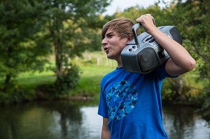 JEUNE ADOLESCENT QUI CHANTE ET ECOUTE DE LA MUSIQUE DANS LA NATURE, RUGLES (27), FRANCE 