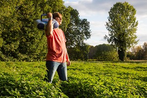 JEUNE ADOLESCENT QUI CHANTE ET ECOUTE DE LA MUSIQUE DANS LA NATURE, RUGLES (27), FRANCE 